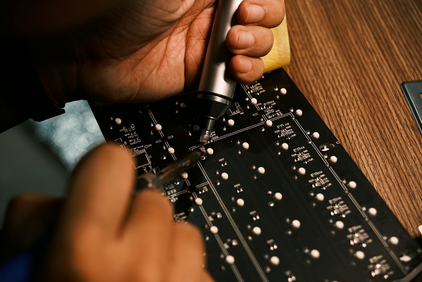 Tekniker använder lödverktyg för att reparera ett kretskort.